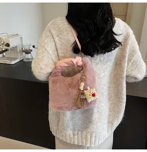 Detail der flauschigen rosa Beuteltasche mit weichem Kunstfell und Bärenanhänger