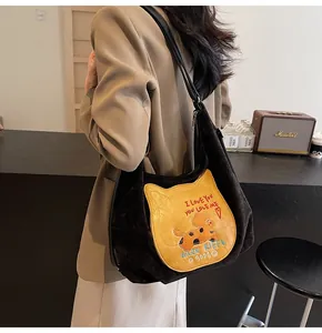 Détail du sac fourre-tout en velours noir avec écusson chat jaune et broderie