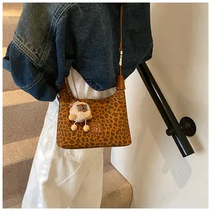 Close-up of leopard print shoulder bag with MAOJ logo and plush alpaca charm detail