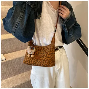 Detailed leopard print shoulder bag with brown strap and white sheep plush charm