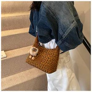 Detail of leopard print shoulder bag with leather logo patch and cute plush bear charm