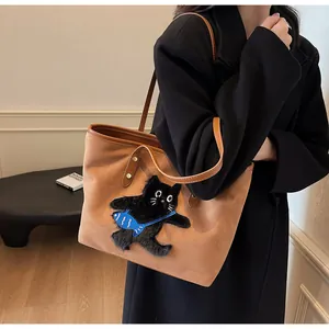 Detailed view of caramel tote bag with cute black cat patch embroidery and leather straps