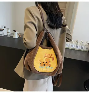 Détail du sac à bandoulière en velours côtelé avec broderie chien et bandoulière cuir