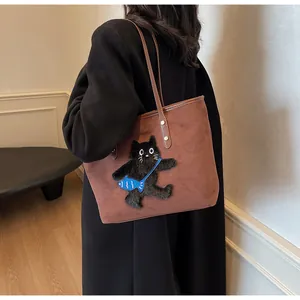 Detail of a dark brown tote bag featuring a cute 3D embroidered cat with blue fish bag