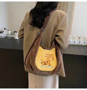 Détail du sac fourre-tout en velours côtelé marron avec poche chat jaune et broderie