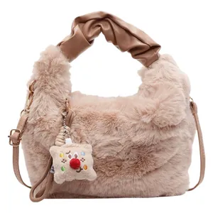 Beige Kunstpelz-Eimertasche mit flauschigem Griff und Umhängeriemen auf weißem Grund