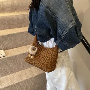Retro leopard print hobo handbag with cute sheep plush pendant shown on shoulder
