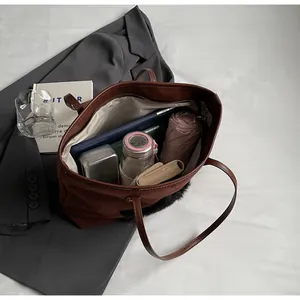 Spacious brown tote bag interior showing laptop, umbrella and travel essentials