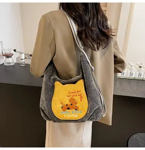 Détail du grand sac cabas en velours côtelé gris avec poche chat jaune et broderies