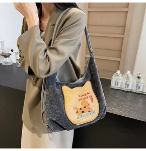 Détail du sac cabas en velours côtelé gris foncé avec broderie chat jaune texturée
