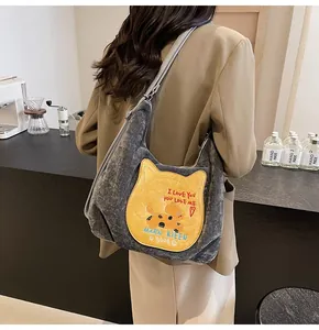 Détail du sac cabas gris vintage avec poche chat jaune et écusson de chien brodé
