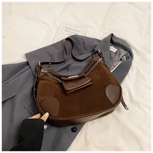 Detail view of brown hobo bag in suede and leather with silver chain and coin purse
