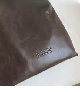 Close-up of mocha brown leather tote bag with embossed logo and vintage texture