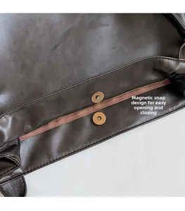 Macro shot of magnetic snap closure and leather stitching on dark brown tote bag