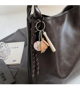 Baseball keychain detail with glove and bat pendant on a brown tote bag