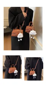 Close-up of brown faux leather bags set with cute white cloud plush pendant charms