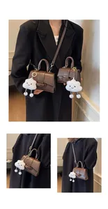 Detail of vintage brown leather crossbody bags with plush cloud charms in two sizes