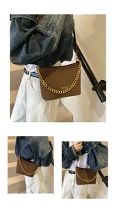 Close-up of brown matte leather bucket bag with chunky gold chain and fashion logo