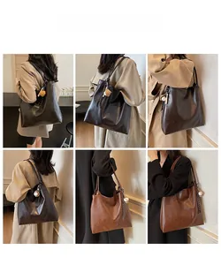 Detail view of large minimalist tote bags in mocha and brown with creative baseball pendant