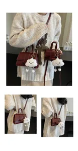 Close-up of vintage burgundy square bags in two sizes with plush cloud charms