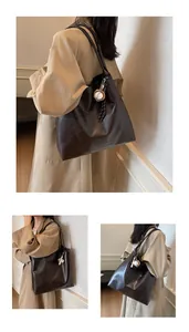 Macro shot of dark brown tote bag with H.SHAN logo and leather texture details