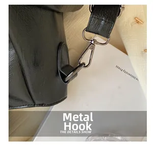 Détail du cuir noir avec crochet métallique gris fusil sur un sac cabas décontracté