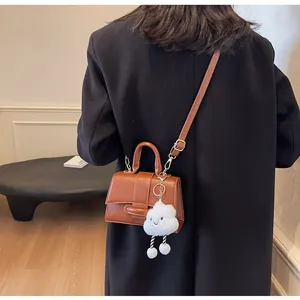 Caramel brown vintage shoulder bag with plush cloud charm detail shown on model