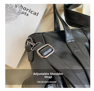 Détail de la bandoulière réglable en cuir noir avec boucle en métal noirci