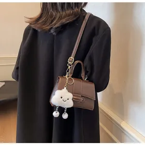 Detailed view of dark brown PU leather shoulder bag with cute cloud charm on model