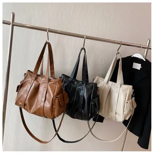 Vue détaillée de grands cabas rétro marron, noir et beige avec texture plissée élégante