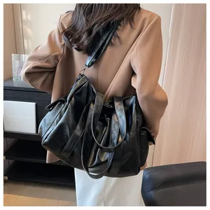Détail du grand sac cabas noir en similicuir souple avec des poches latérales pratiques