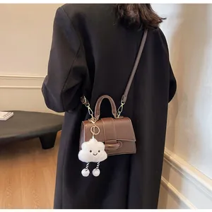 Detail of dark brown vintage shoulder bag with golden hardware and cloud charm
