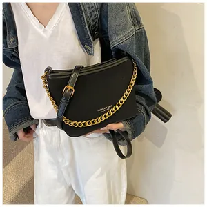 Detail of black pebbled leather bucket bag featuring thick gold chain and adjustable strap