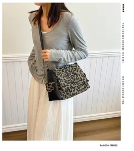 Detail of leopard print canvas bag with black leather straps and side pocket