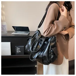 Détail du grand sac cabas noir avec poche latérale à rabat et design à double bandoulière
