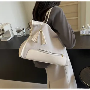 Détails du sac cabas en toile avec lanières en cuir et pendentif à franges au café