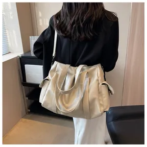 Détail d'un grand sac cabas plissé en cuir PU beige porté par un mannequin en intérieur