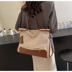 Détail d'un grand sac cabas en toile avec garniture en cuir marron sur mannequin