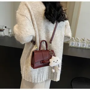Deep wine red shoulder bag shown on model with a cute plush cloud charm detail