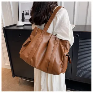 Grand sac cabas marron en similicuir porté par un mannequin pour un look chic décontracté
