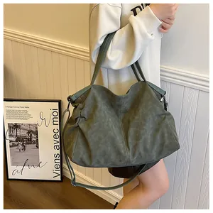 Macro detail of the dark green tote bag showing matte texture and double stitching