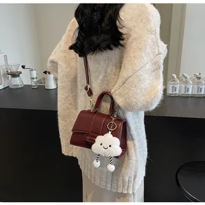 Detail of dark red flap handbag with cloud charm and high-gloss PU leather texture