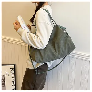 Side view of dark green matte tote bag with adjustable strap on female model