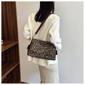 Detail showing the adjustable leather strap and classic leopard print on a canvas tote bag