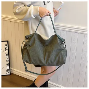 Detail of dark green matte tote bag with adjustable strap and vintage texture