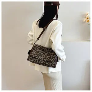 Detail view of the brown leopard print crossbody bag showing its texture and size