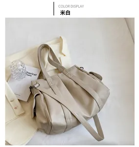 Gros plan détaillé du sac fourre-tout beige en similicuir avec poche latérale à rabat