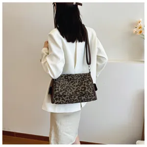 Detail of leopard print canvas tote bag with adjustable brown leather shoulder strap