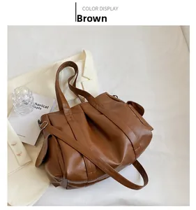 Vue détaillée du sac fourre-tout marron avec poche sur un fond minimaliste chic