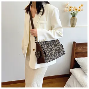 Detail view of the leopard print texture and dark brown leather strap of the vintage tote bag